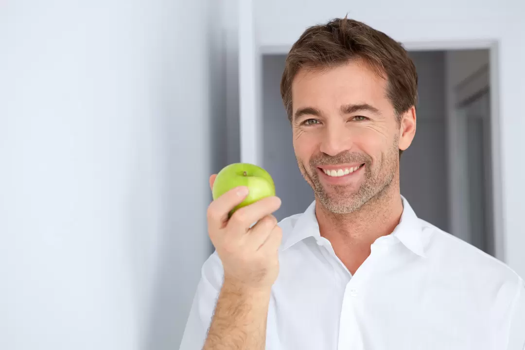 Ein Mann isst einen Apfel, um Macht zu haben
